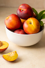 Naklejka na ściany i meble Whole nectarine peaches, fresh red fruits in a bowl. Neutral background.