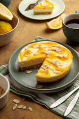 Lemon cheesecake tart or pie, over brown background. Delicious dessert with fresh fruits.