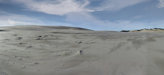 Lacka dune in Slowinski National Park. white sandy hill against a blue sky with clouds. Leba, Poland
