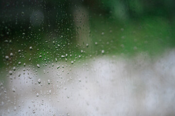 Rain drops of car windscreen with green background