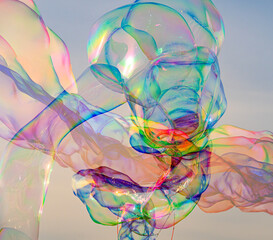 Sunlight refracting through Large colorful bubbles on the ocean coast during sunset.