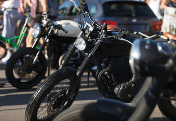 Fototapeta na wymiar Custom bobber motorbike painted in matte black. Classic tuner motorcycle on bike show.