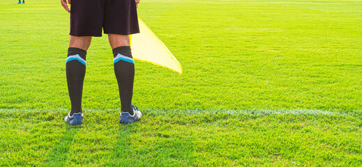 Low section of Soccer assistant referee (Linesman) standing on the edge of field, panoramic view...