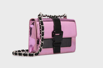 Side view on women's pink Glossy Shiny Leather bag Handbag with clasp buckle and chain strap. Shoulder bag isolated on White Background