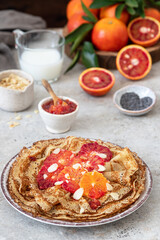 French Crepe with bloody oranges with  syrup and almonds. Delicious breakfast with pancakes