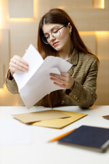 Obraz premium Business woman looks at bills and mail in the office at the table.