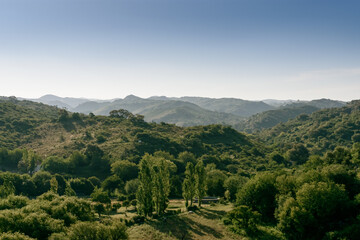 Fototapeta premium Valle entre los cerros. Al fondo las montañas hasta el horizonte en un día diáfano. Viajes y turismo en Córdoba. Argentina.