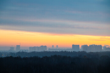 Fototapeta na wymiar early winter cold dawn over park and city on horizon