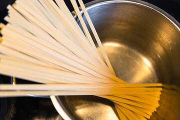 top view of portion of uncooked linguine pasta in saucepan