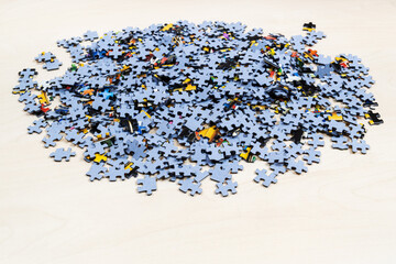 pile of blue puzzle pieces on light brown wooden table
