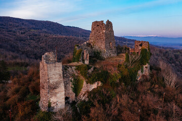 Fototapeta na wymiar Ancient old fortress. Shkhepi Castle ruin in mountains at the sunset, aerial drone view