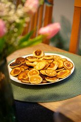 Smal mini pancakes on the table with tulpans, spring colors