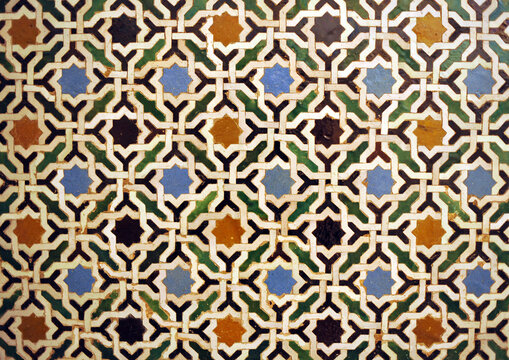 Arab geometric mosaic of the Alhambra in Granada, Spain. Al Andalus tiles called alicatados. Arabic tiles of eight pointed stars. Alhambra Palace in Granada, a UNESCO World Heritage Site