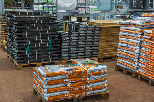 Close up view of bags with sowing soil and withdrawn wooden pallet collars for gardening. Gardening concept. Sweden.