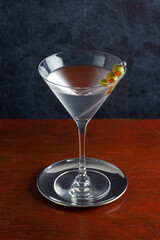 Classic Gin or Vodka Martini Cocktail Shaken with a Garnish of Olives on A Wooden Bar