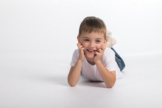 a boy of European appearance lies on a white background with a smile