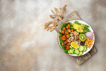 Healthy vegetarian cuisine with a tofu salad with avocado, chickpeas, cucumber and mushrooms. banner, menu, recipe place for text, top view