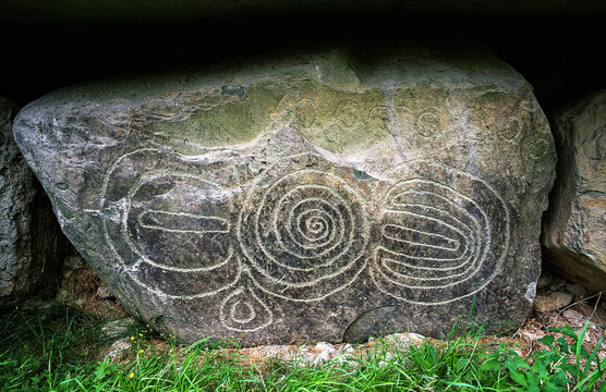 Knowth prehistoric Neolithic passage tomb, Boyne Valley near Newgrange, Ireland. Spiral motif on massive exterior curb stone. Part of Bru na Boinne