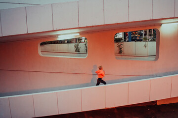 Women in sports clothes running in a modern urban environment et night time. The concept of a...