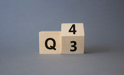From 3rd Quarter to 4th symbol. Turned wooden cubes with words 3rd Quarter and 4th Quarter....