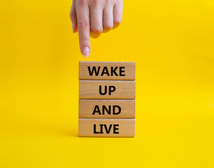 Wake up and live symbol. Wooden blocks with words Wake up and live. Beautiful yellow background....
