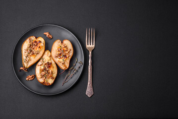 Delicious baked pear with dorblu cheese, walnut and honey on a textured concrete background