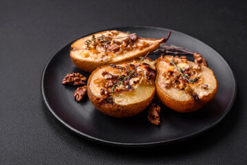 Delicious baked pear with dorblu cheese, walnut and honey on a textured concrete background