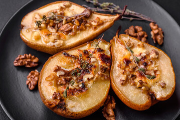 Delicious baked pear with dorblu cheese, walnut and honey on a textured concrete background