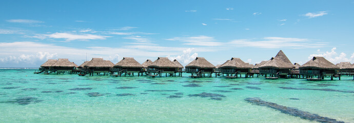 Luxury overwater bungalows in lagoon of Moorea Island, French Polynesia. - obrazy, fototapety, plakaty