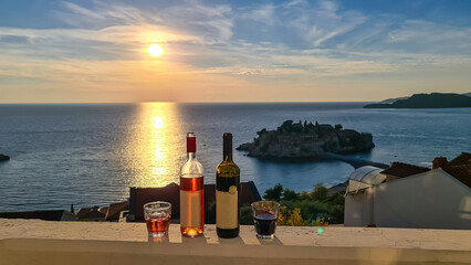 Drinking wine on balcony in luxury hotel in Budva Riviera with scenic view on idyllic Sveti Stefan...