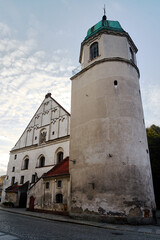 Fototapeta na wymiar Brick tower of a historical church in the city of Wschowa in the evening