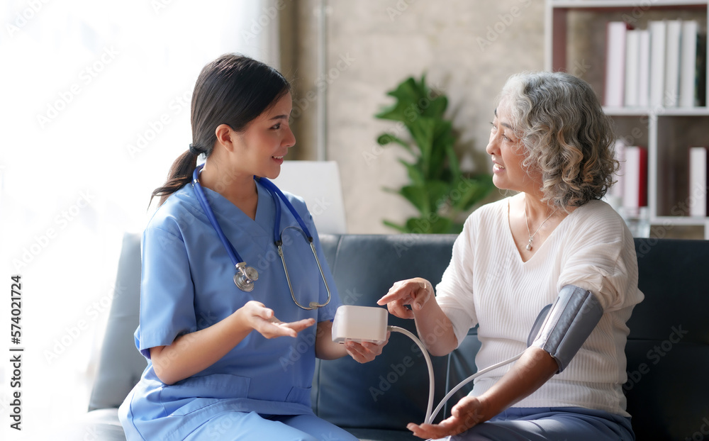 Canvas Prints Asian female doctor measuring blood pressure for an elderly female patient.