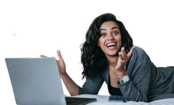 Excited African American young woman in grey cardigan toothy smiles laying on couch with laptop surprised opened mouth in disbelief amazed by new gadget. Student against transparent background. Winner