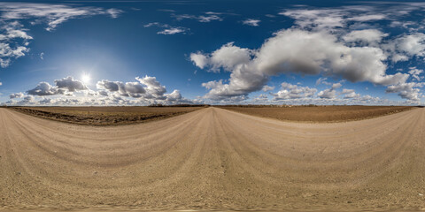spherical 360 hdri panorama on gravel road with clouds on blue sky in equirectangular seamless projection, use as sky replacement in drone panoramas, game development as sky dome or VR content