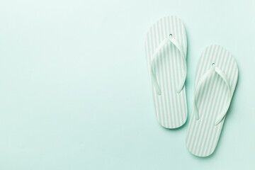 Striped flip flops on color background, top view