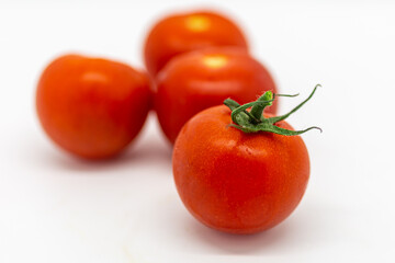 Vibrant red salad tomatoes with a white background