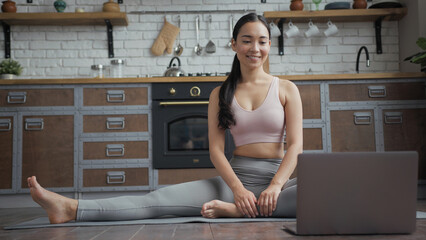 Healthy Asian yoga woman doing stretching online lessons