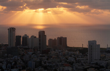 Tel Aviv orange sunset view. Sunrays on the sea, high-rise buildings