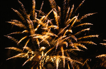 Fireworks firework display exploding rocket skyrocket explosion starburst into black gold texture...