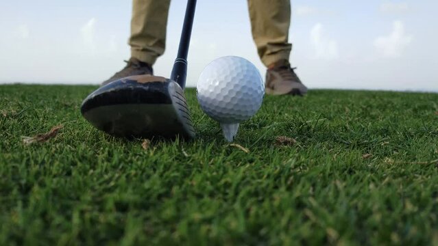 Golpe de golf, golpe de salida desde el tee. Primer plano de golpe de golf en c&eacute;sped con bola blanca, con el sonido del golpe a la bola