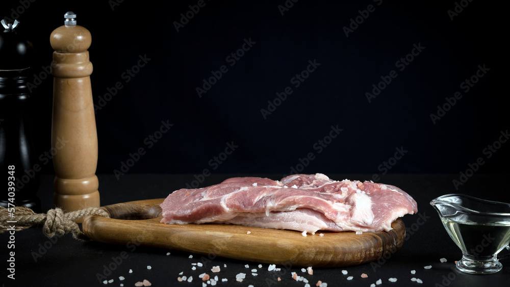 Wall mural the chef's hands prepare a meat steak and add salt and spices, restaurant menu or recipe