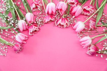 Pink tulips and white gypsophila flowers bouquet on a pink background. Mothers Day, birthday celebration concept. Copy space for text. Mockup