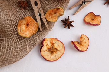 A pattern of a pile of dried apples, sliced, on a white concrete or slate background. Dried fruit chips. Healthy food. Top view