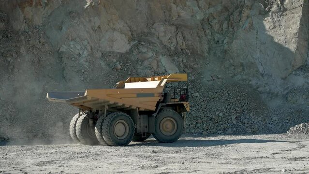 Loaded truck is driving along the copper, gold mine open pit deposit, slow motion