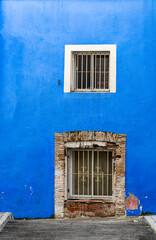 Fototapeta na wymiar Blue wall with old windows