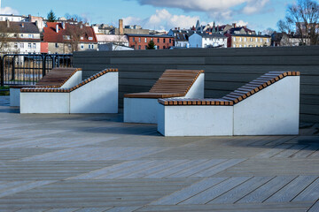 Wooden deck chairs on a wooden terrace.  View of the city center.