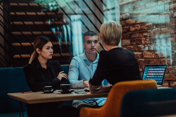 Happy businesspeople smiling cheerfully during a meeting in a coffee shop. Group of successful business professionals working as a team in a multicultural workplace.