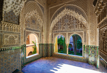 Fantastic interior of  room in palaces of alhambra: Ceramic tiles; stone; wood carvings; whimsical flower ornaments; The form of Arabic writing; lush decoration; arches; vaults;