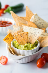 Homemade Keto diet tortilla chips served with guacamole and salsa for dipping.
