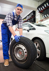 Obraz na płótnie Canvas Portrait of mechanic in overalls in auto repair shop
